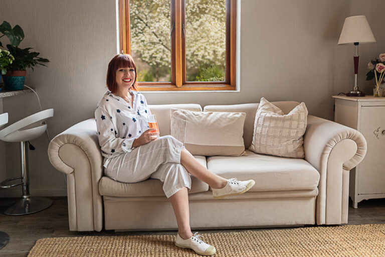 Indoor portrait of a woman sitting casually on a couch by Katja Photography