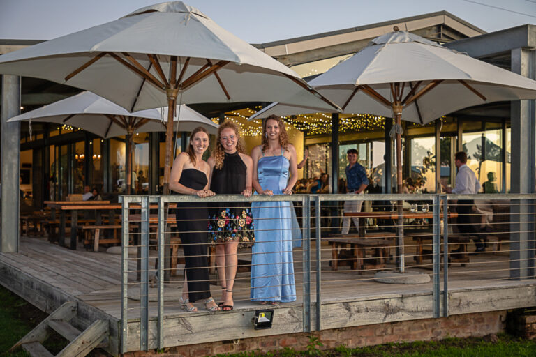 Outdoor portrait of three friends standing on a deck and smiling by Katja Photography