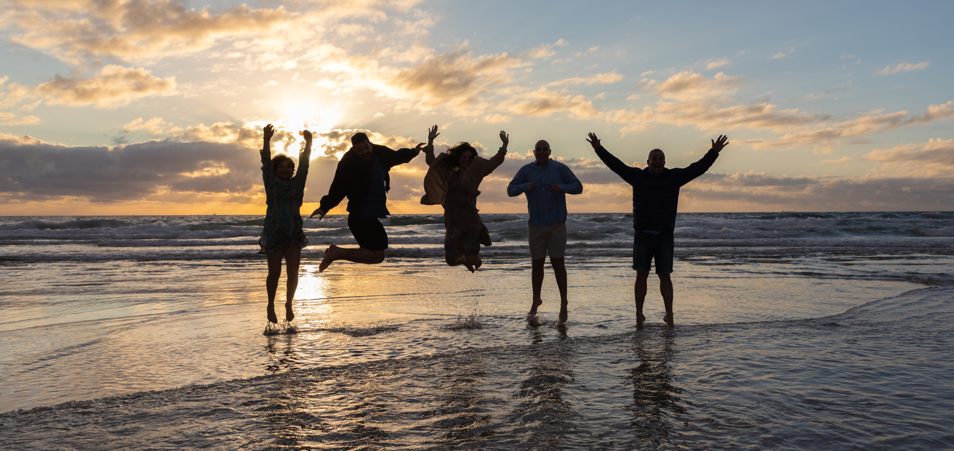 Family jumping on the beach by Katja Photography